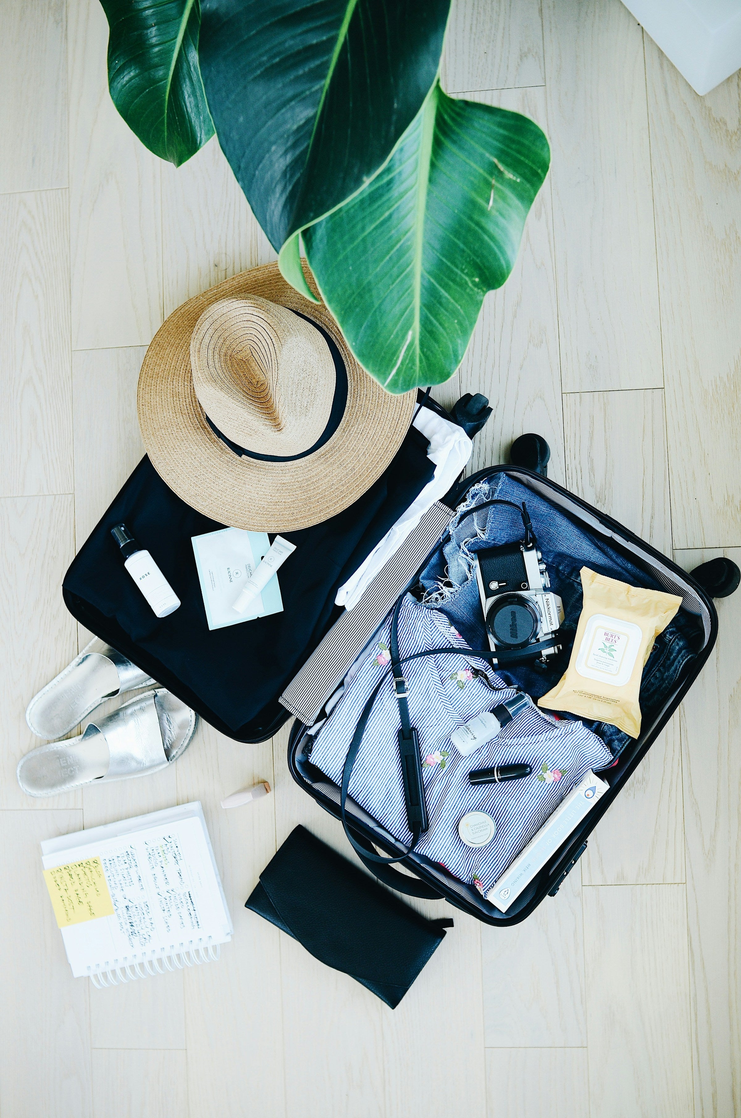 Valise ouverte et bien rangée avec chapeau et essentiels de voyage
